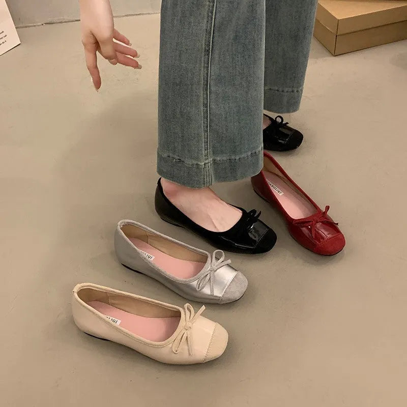 Wine red Mary Jane ballet flats with a bow and square toe on a rubber sole.