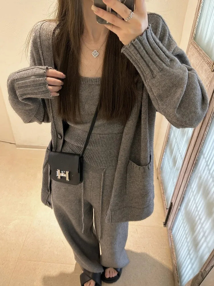 Women's loose-fit wool-blend cardigan three-piece set with vest and suspender trousers in beige.