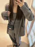 Women's loose-fit wool-blend cardigan three-piece set with vest and suspender trousers in beige.