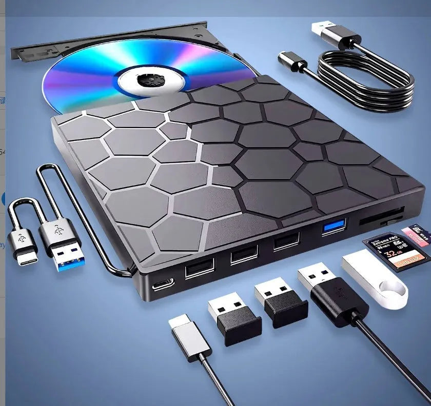 Black external USB CD DVD writer drive on a desk next to a laptop