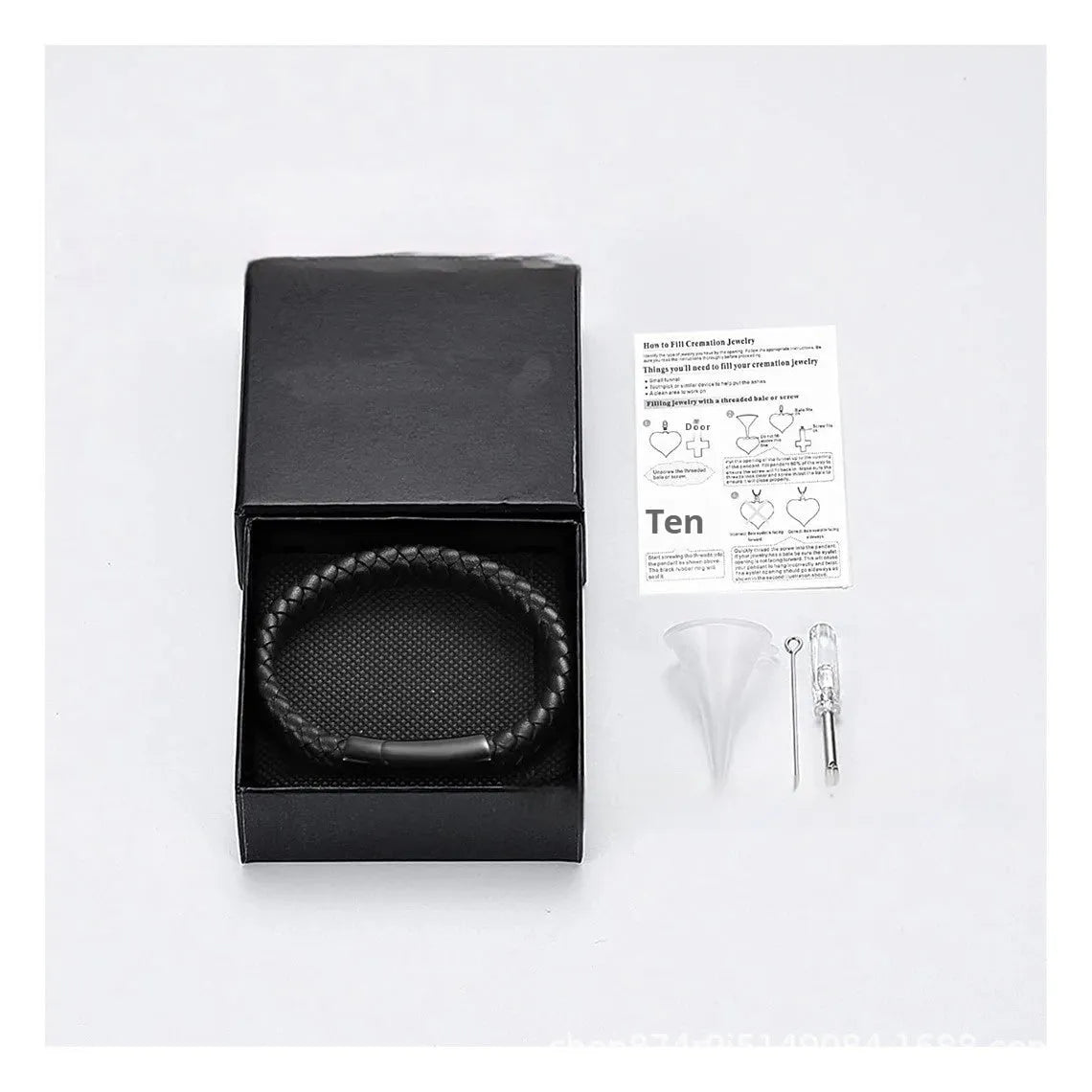 Black leather and stainless steel casket bracelet with engraved text on a gift box.