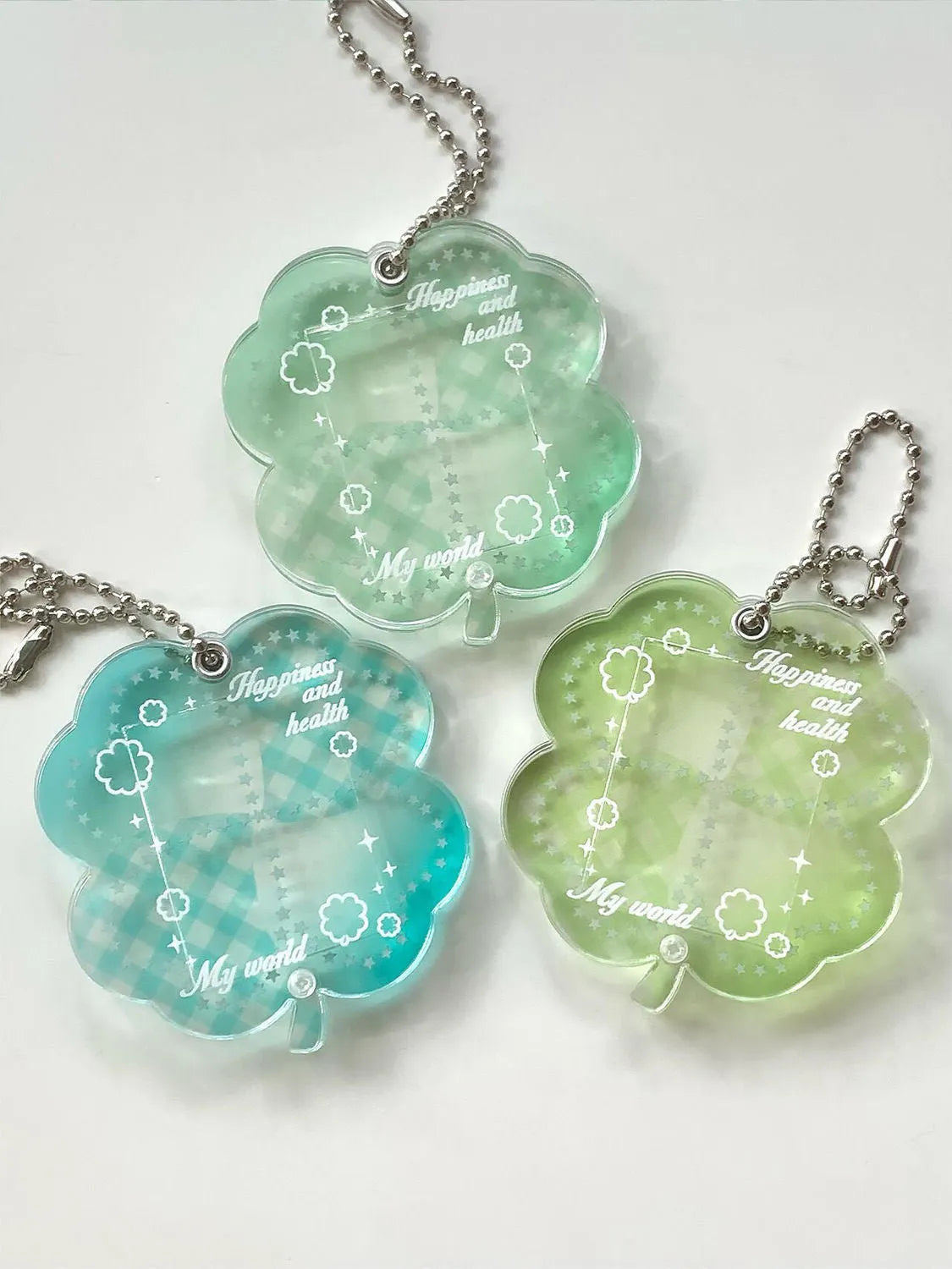 Lucky four-leaf clover shaped acrylic pendant keychain in blue, green, or mint green colours.