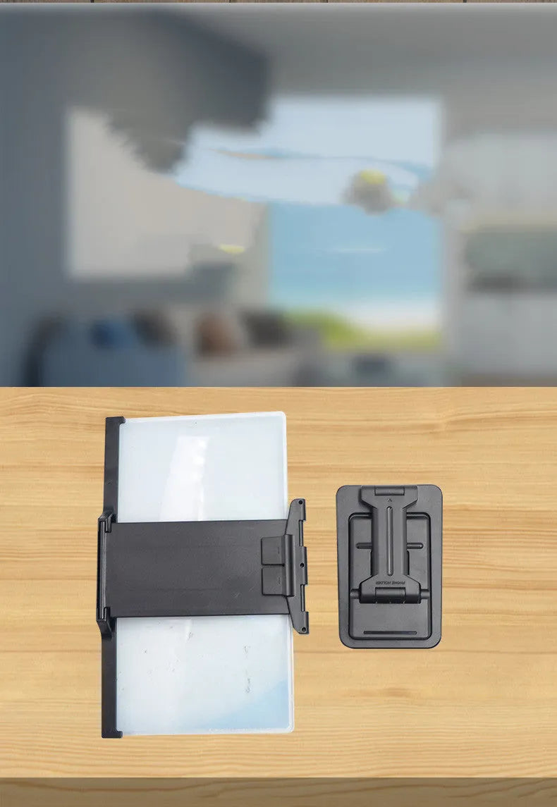 Black mobile phone screen amplifier with detachable phone holder on desktop surface