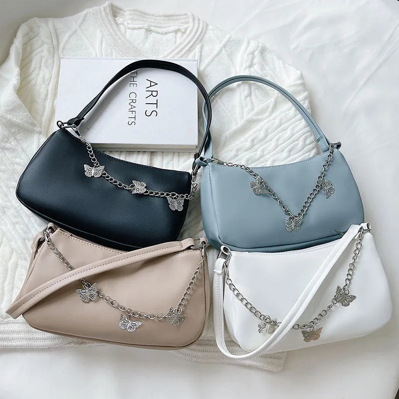 Butterfly chain underarm bag in black PU leather with crossbody strap and internal organisation pockets