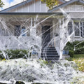 White cotton spider web Halloween decoration props draped across corner with multiple spiders