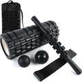 Black handheld foam massage roller bar with six white textured gear pieces on a 33cm shaft.