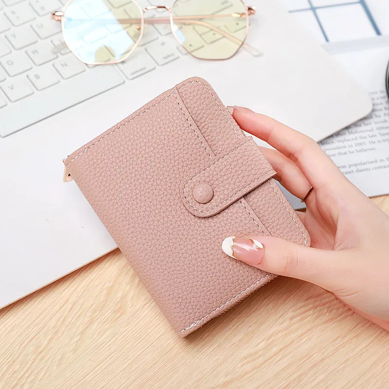 Women's beige lychee pattern short wallet made of PU, showing sewing thread detail and open organiser compartments.