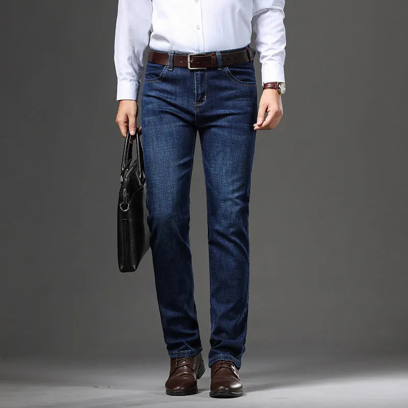 Man wearing loose fit straight-leg stretch jeans in blue denim for a business casual look.