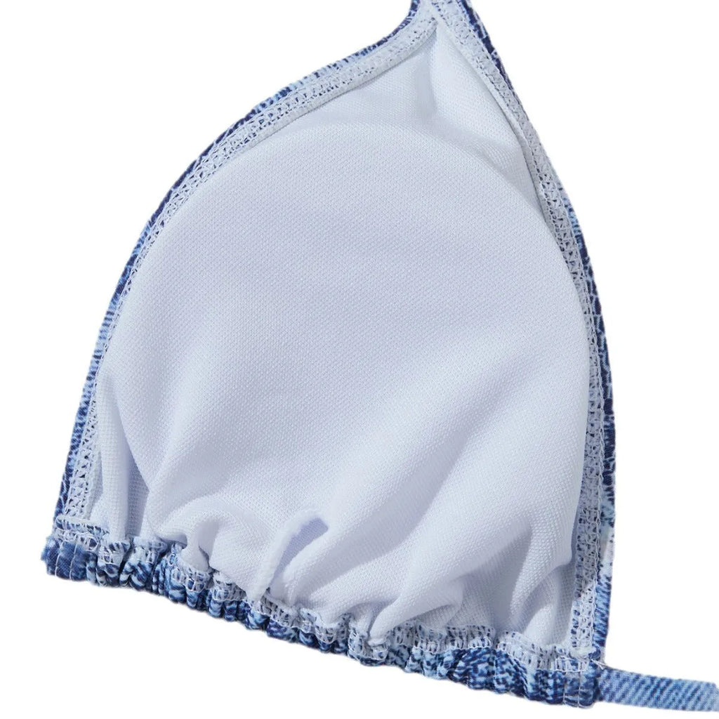 Women's denim blue printed bikini set with halterneck top and side-tie bottoms on a mannequin.