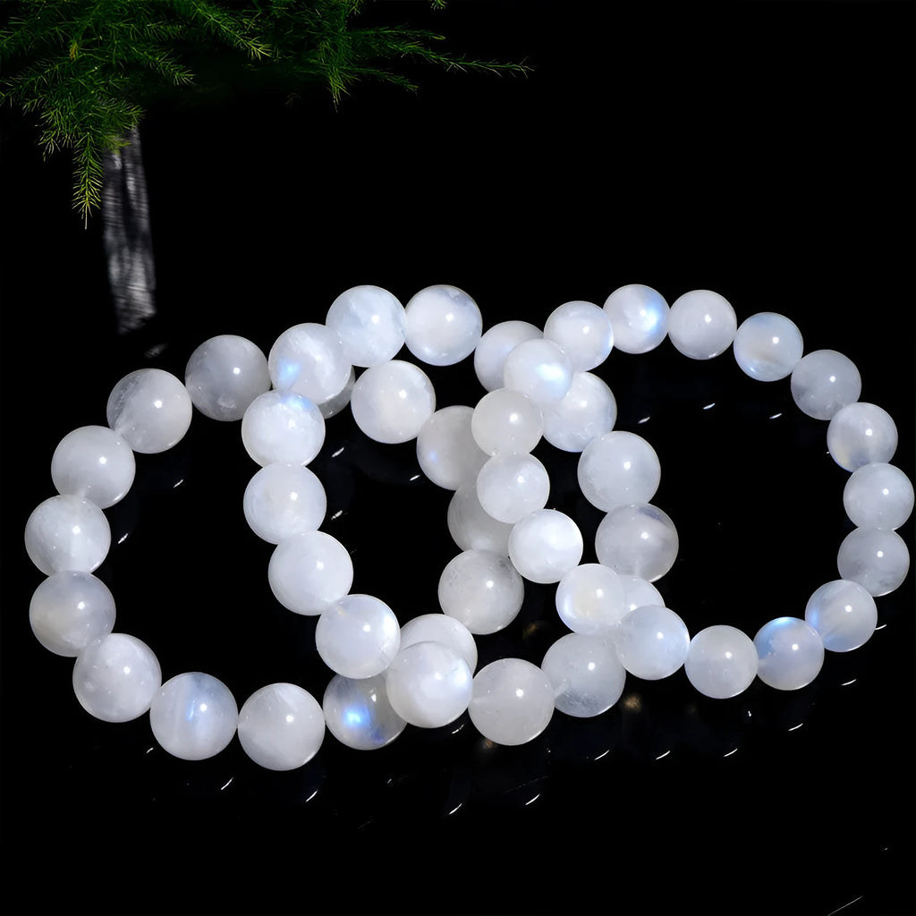 Natural blue moonlight round moonstone bead bracelet on a white background showing polished spherical beads.