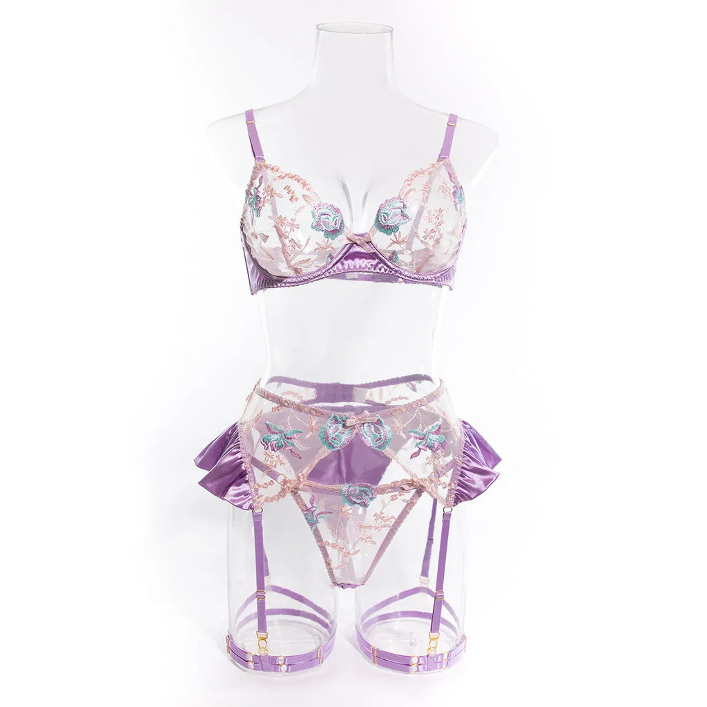Light purple satin lingerie four-piece set with bra, briefs, garter belt, and suspenders