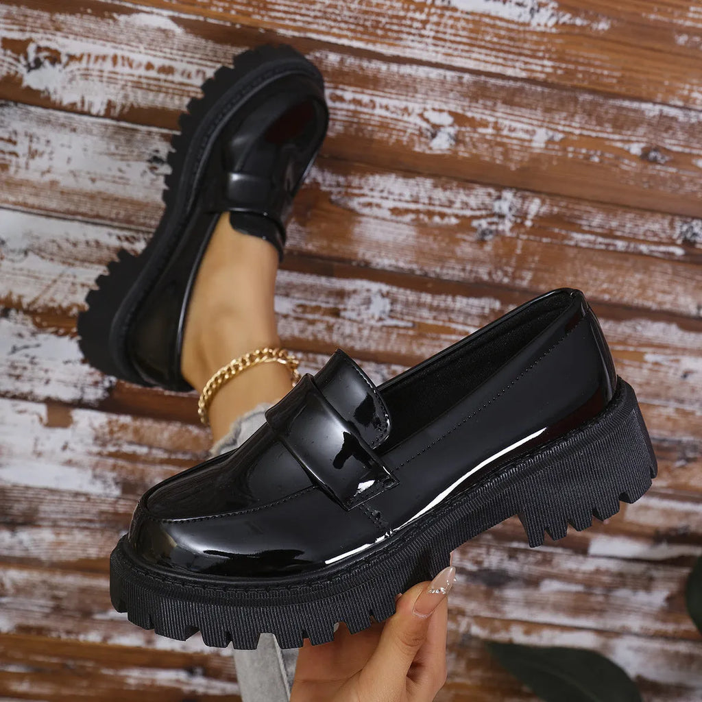 Women's plus size black slip-on loafers with a chunky mid-heel and rubber sole.