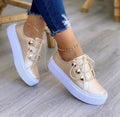 Women's white lace-up flats sneakers with silver rivet detail on the casual round-toe upper.