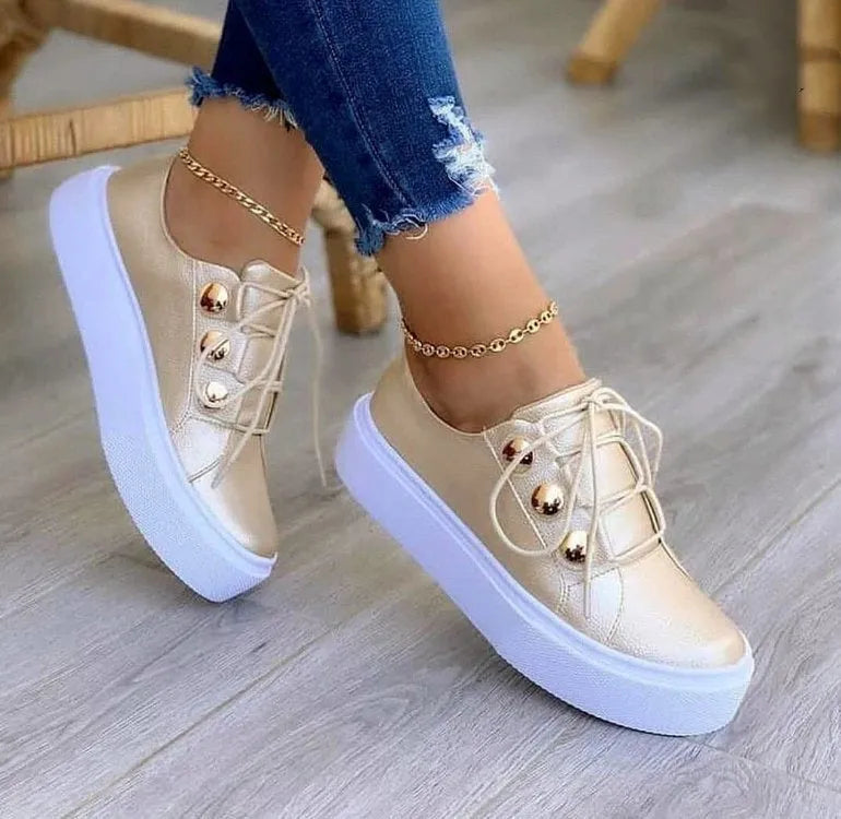 Women's white lace-up flats sneakers with silver rivet detail on the casual round-toe upper.