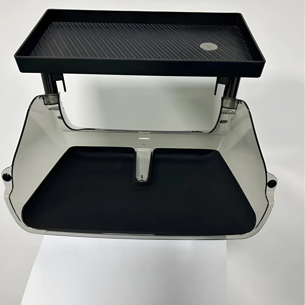 Black ABS plastic storage box installed under the screen of a Tesla Model Y centre console.