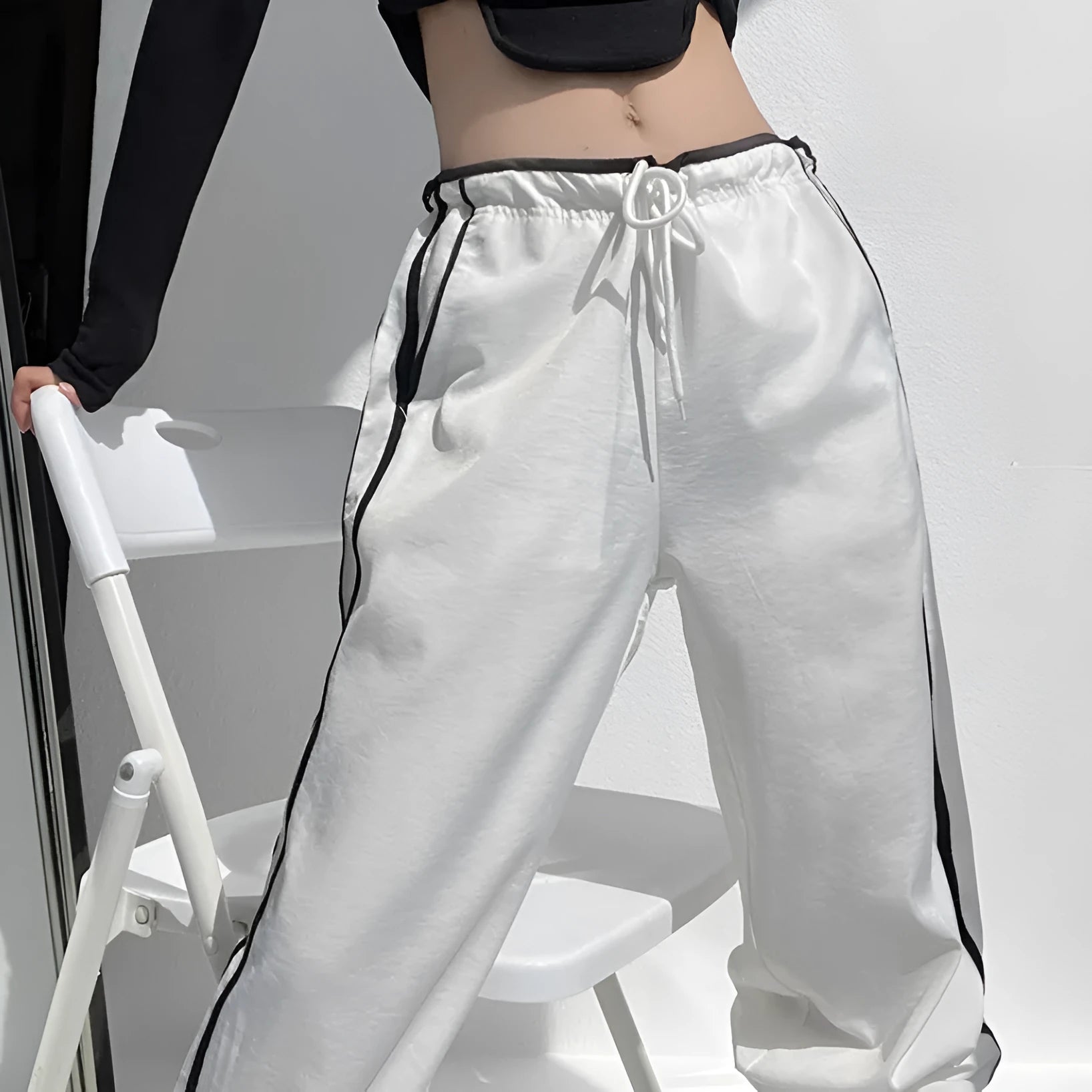 Navy blue loose straight-leg trousers with white parallel ribbon detail on the legs.