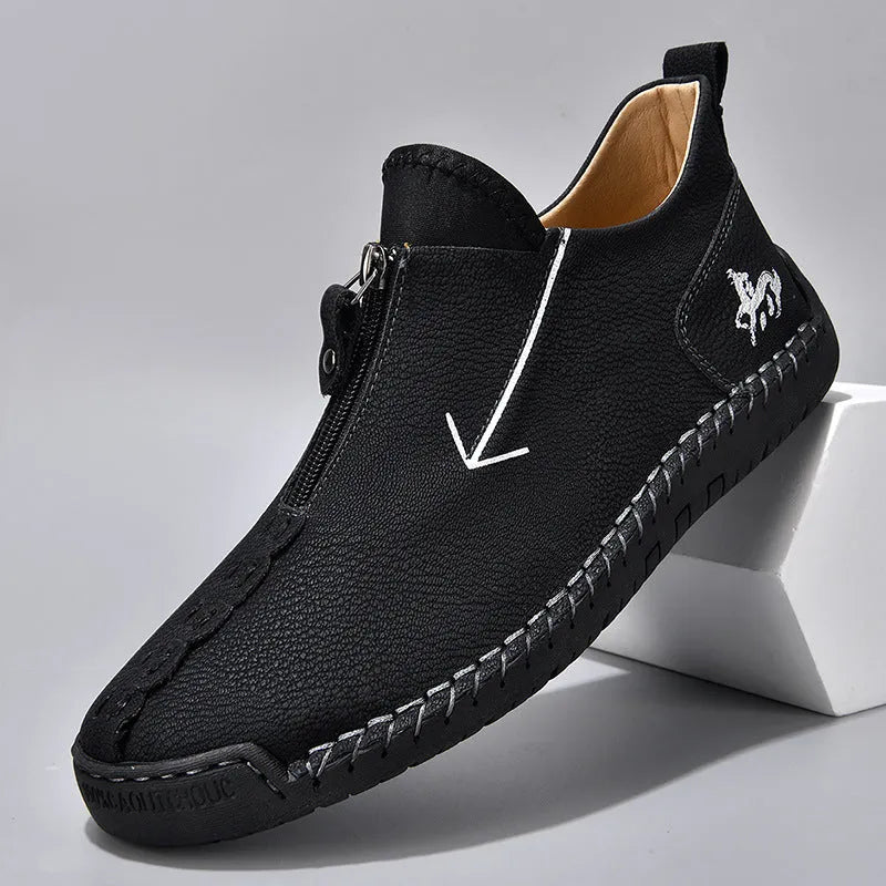 Men's black leather boots with front zipper and hand-stitched detailing, mid-calf height with low rubber sole