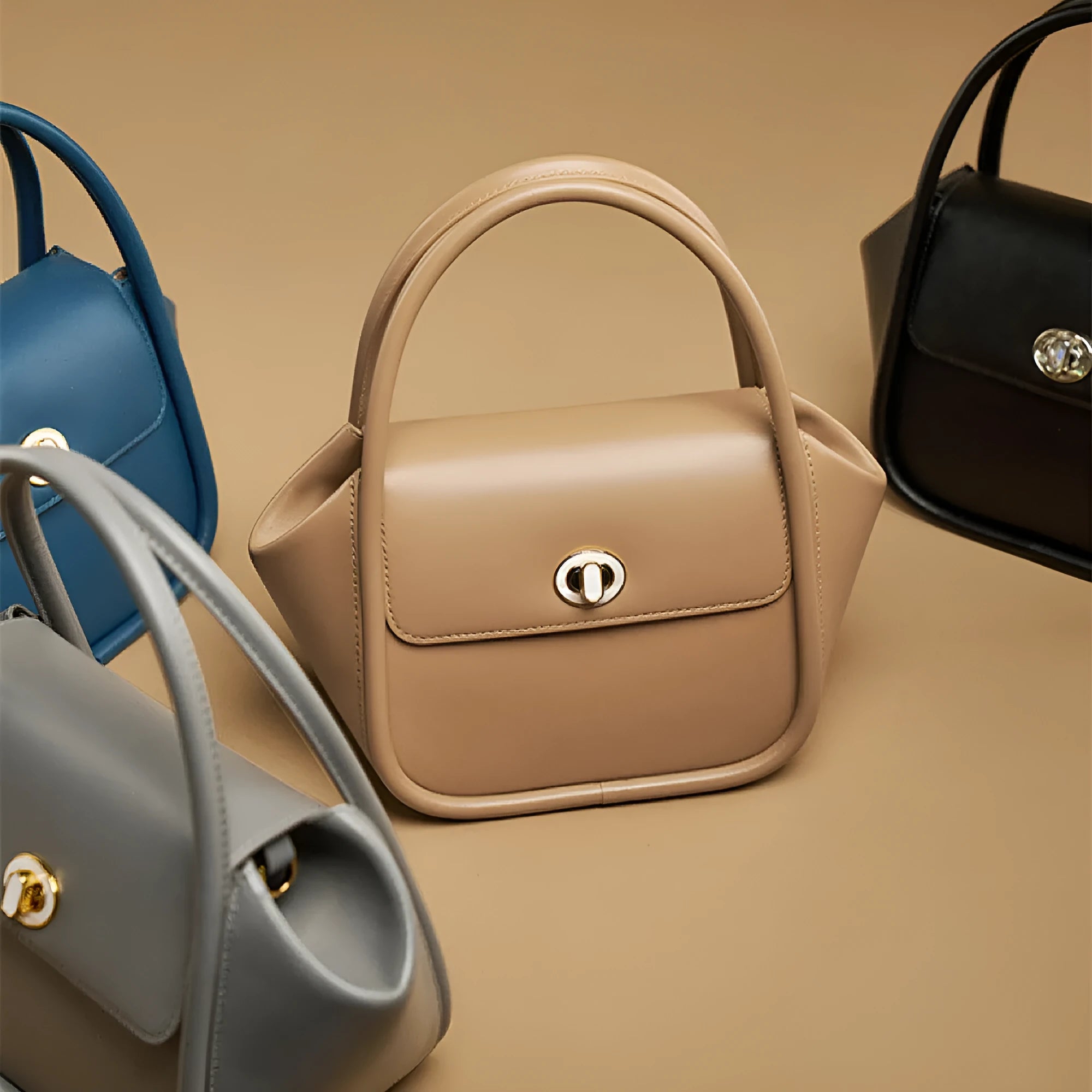 A wing-shaped cow leather tote bag with a buckle latch closure, shown in blue with a single cross-body strap.