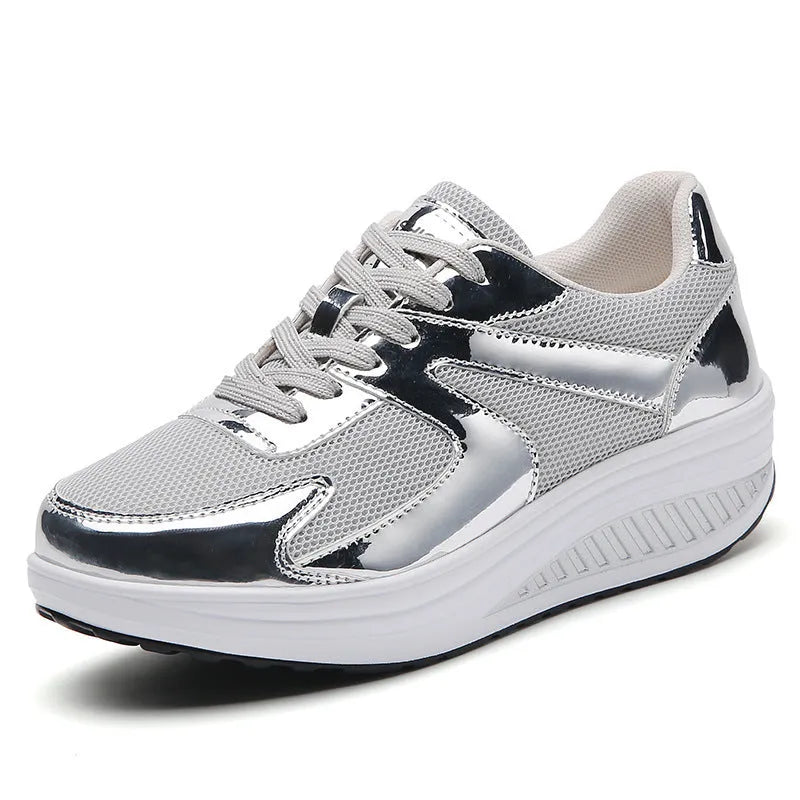 Women's gold patent leather mesh sports shoes with cross straps and platform sole.