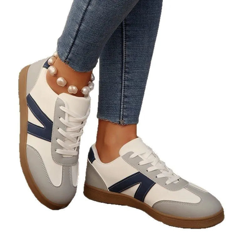 Blue women's low-top flat training shoes with lace-up front and rubber sole.