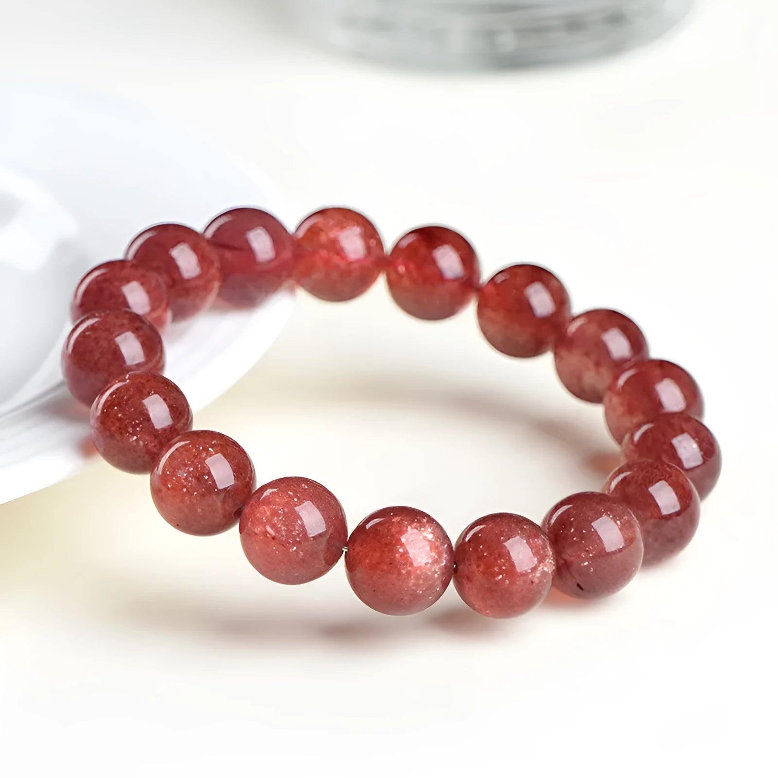 Natural cherry red strawberry quartz bracelet with geometric cut stones on wrist