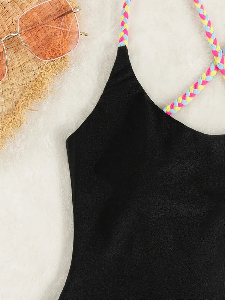 Black solid colour one-piece swimsuit with a backless and sleeveless design on a mannequin.