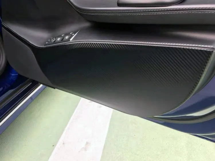 Four carbon fibre protective film pieces for Tesla Model S interior door panels.