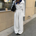 White women's wide-leg trousers with a stripe detail and zip fastening, laid flat.