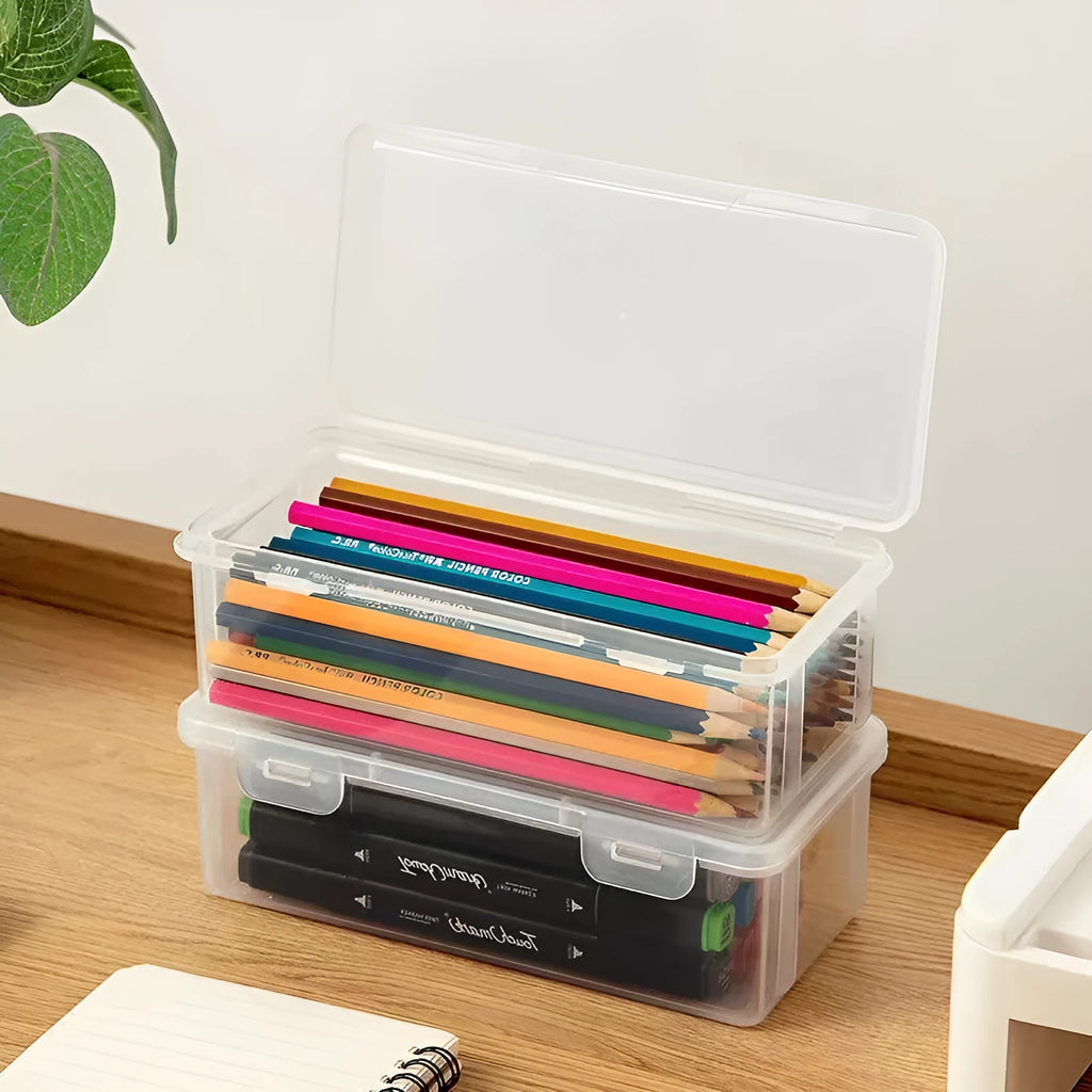 Transparent plastic storage box containing coloured pencils and drawing materials