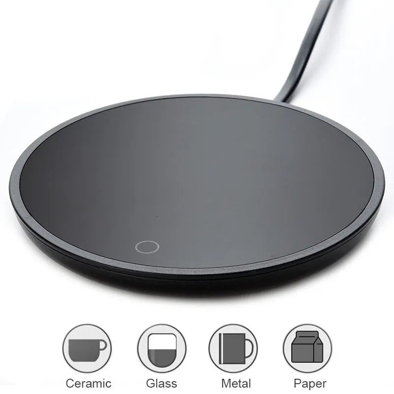Black coffee mug warmer with temperature control dial on desk