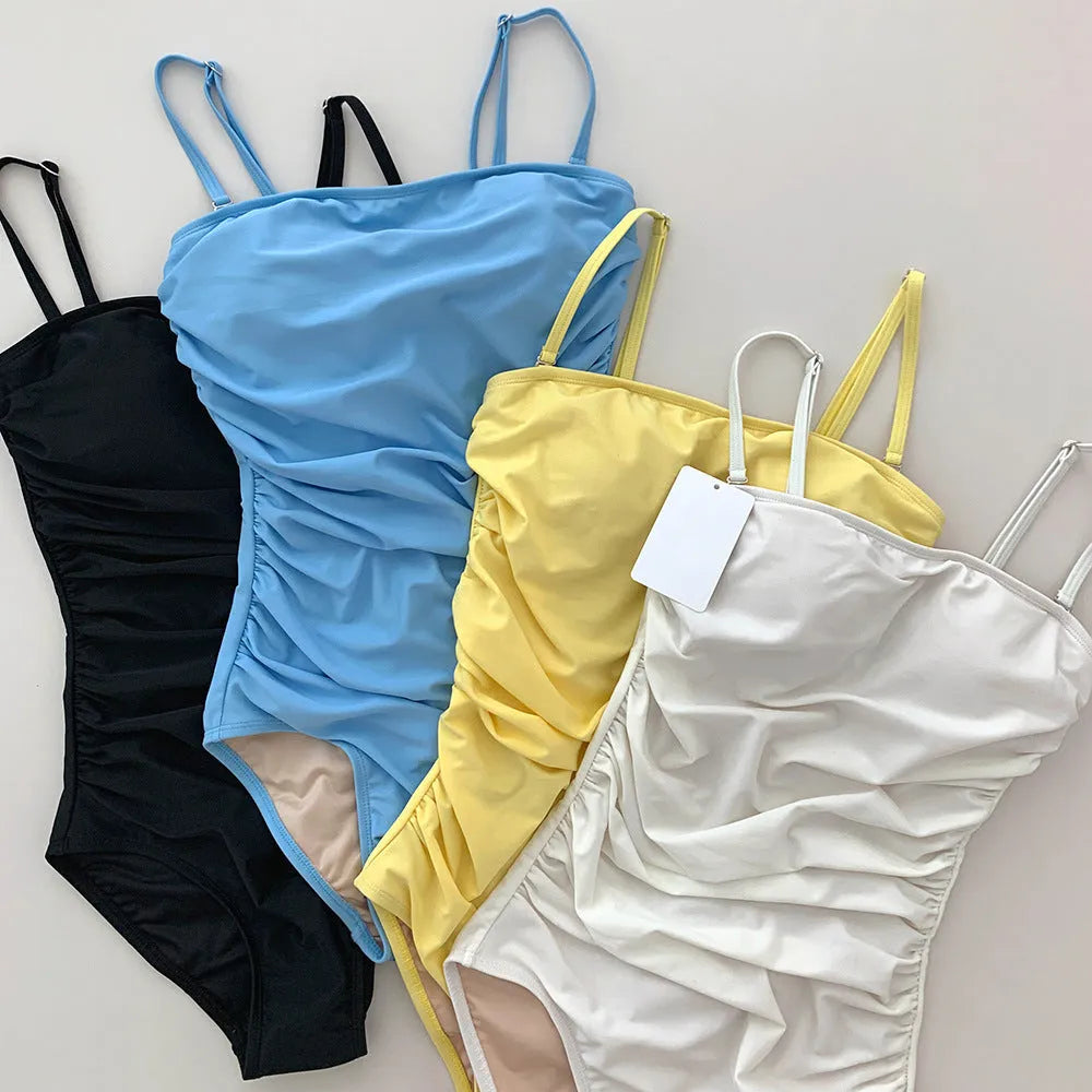 Blue sling style one-piece women's swimsuit with belly pleats and a slim fit design.