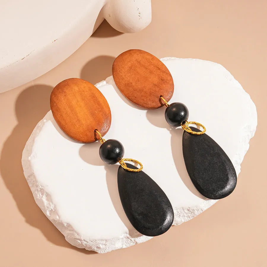 Brown-black wooden retro earrings with elliptical design and silver needle details