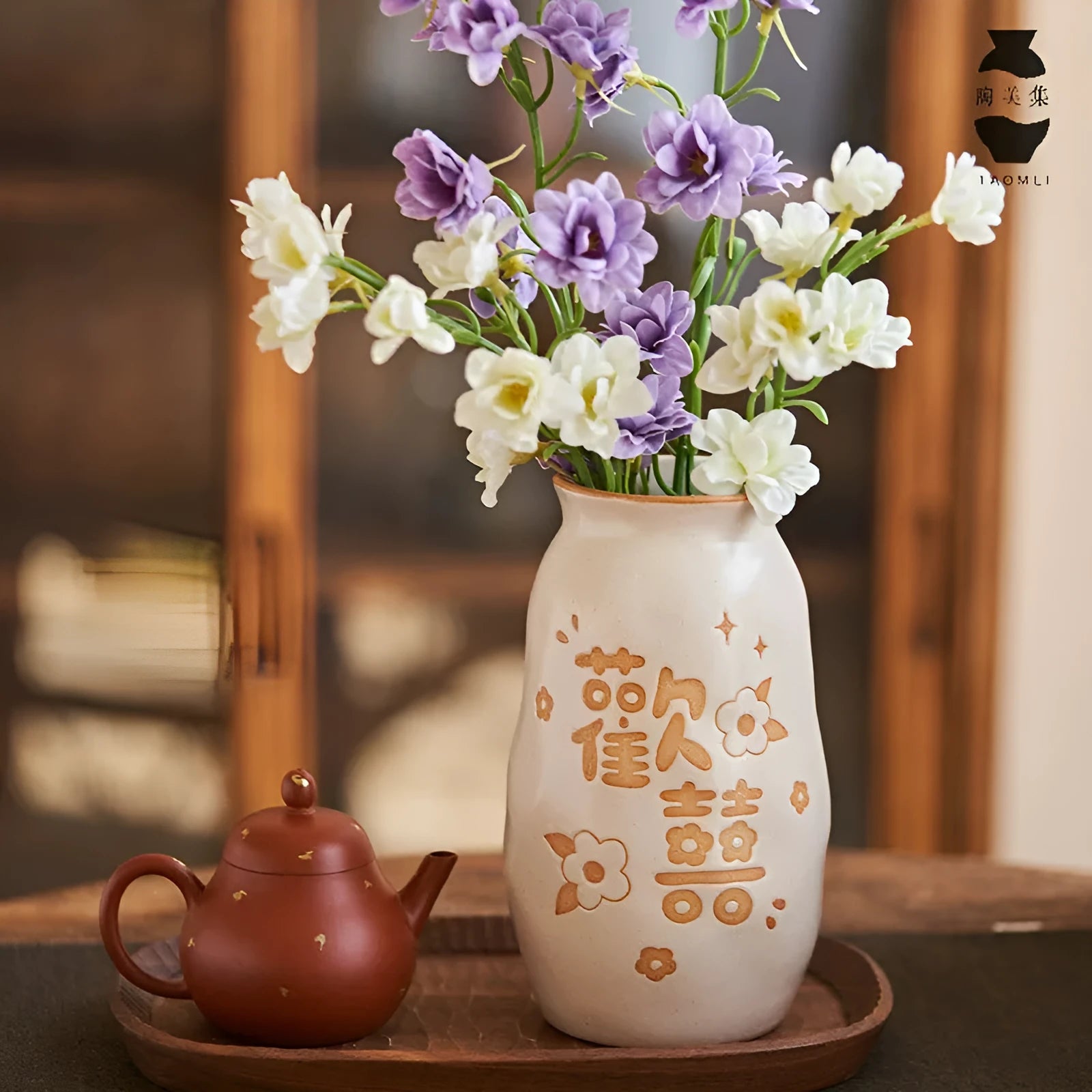 Chinese hand-painted ceramic joy vase with carved decorations on wooden desktop