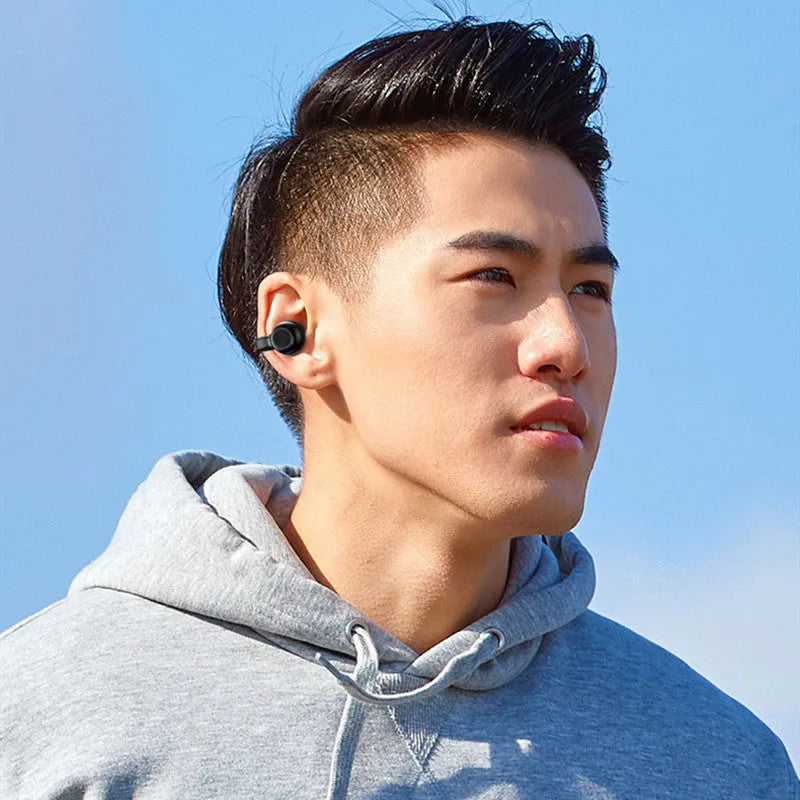 Wireless Bluetooth clip-on bone conduction earphones in black or white packaging