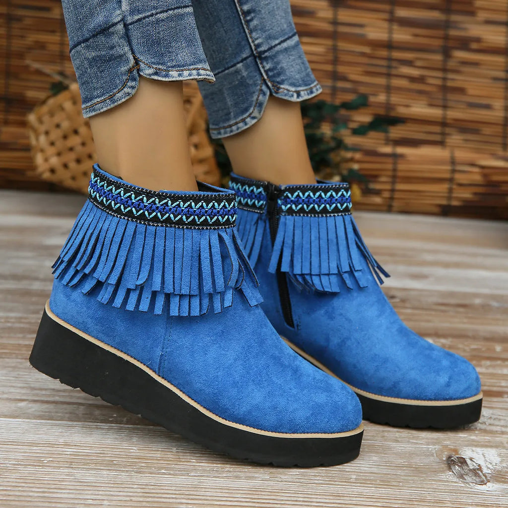 Women's black suede ankle boot with wedge heel, platform sole, side zip, and tassel detail.