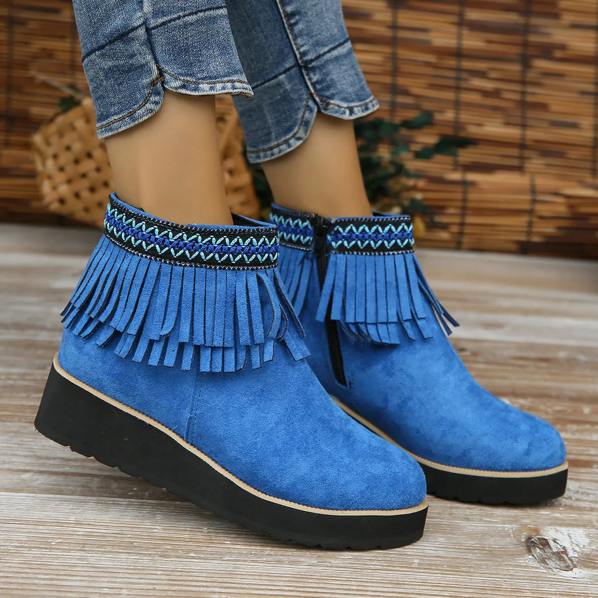 Women's black suede ankle boot with wedge heel, platform sole, side zip, and tassel detail.