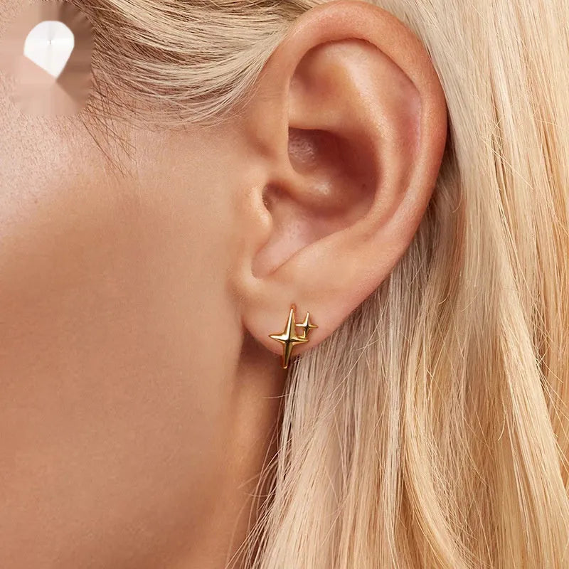 Minimalist star design silver ear clip with XINGX detail on a plain background.
