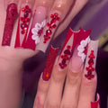 Sweet floral pattern fake nails with prismatic red diamond finish on long European square shape.