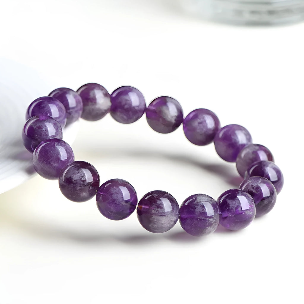 Snow Mountain feather amethyst crystal bracelet with geometric beads and Ruyi elements on a wrist.