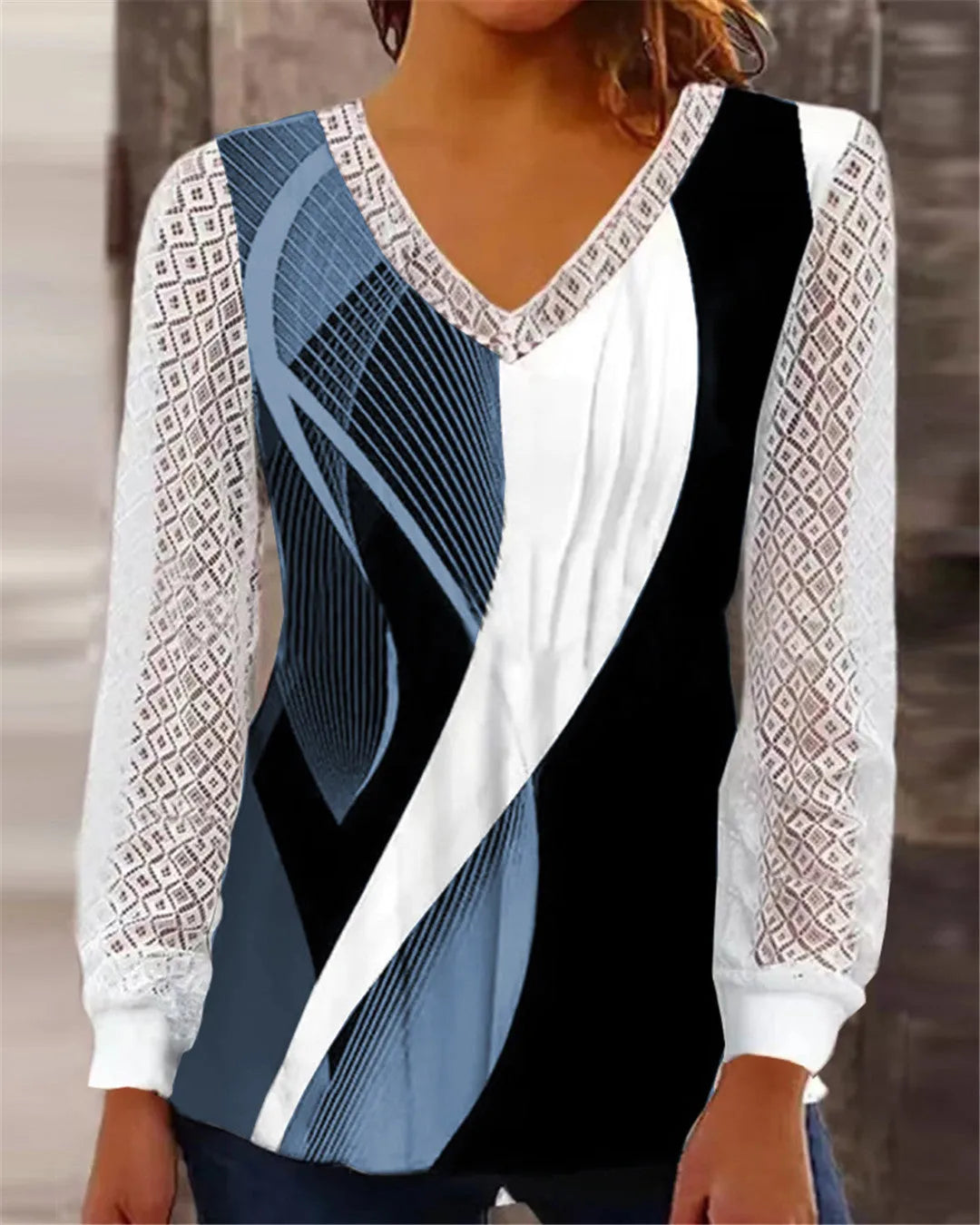 Purple loose V-neck top with lace print detail, long sleeves, on a hanger.