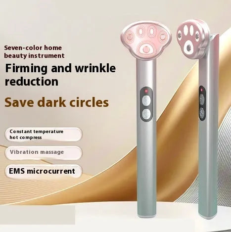 Gradient pink Cat's Paw micro-current eye massager with charging cable.