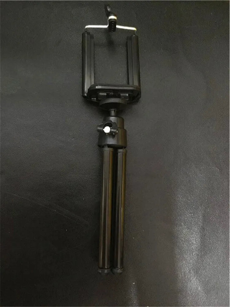 Black desktop phone holder with two-section metal bracket on a wooden desk.