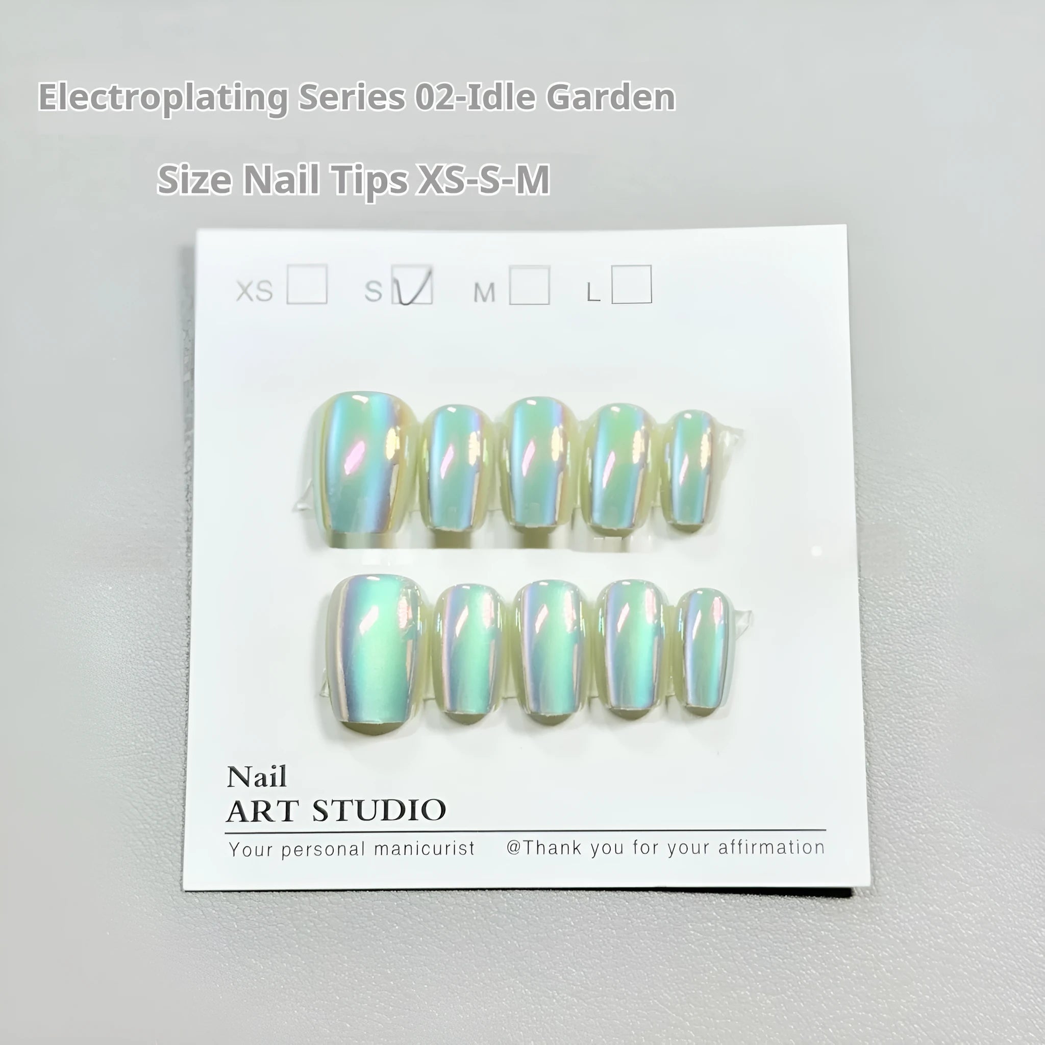 Electroplated cat's eye false nails with aurora glitter on short ladder shapes in sizes XS, S, and M.