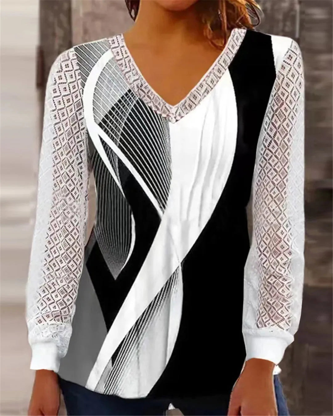 Purple loose V-neck top with lace print detail, long sleeves, on a hanger.