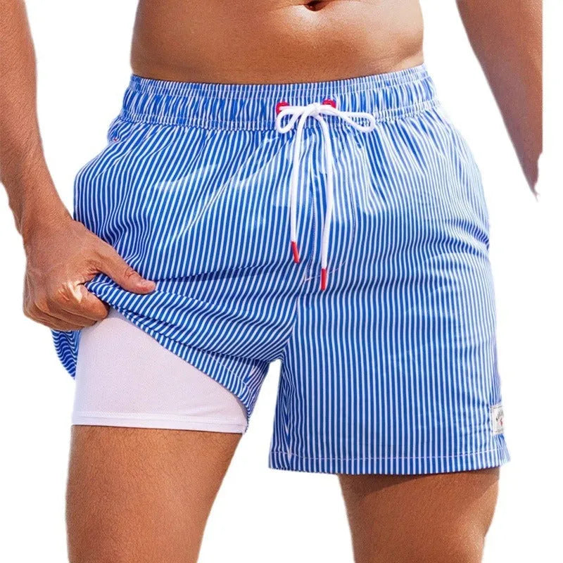 Men's loose-fit floral swimming trunks in quick-dry spandex fabric on a blue background.