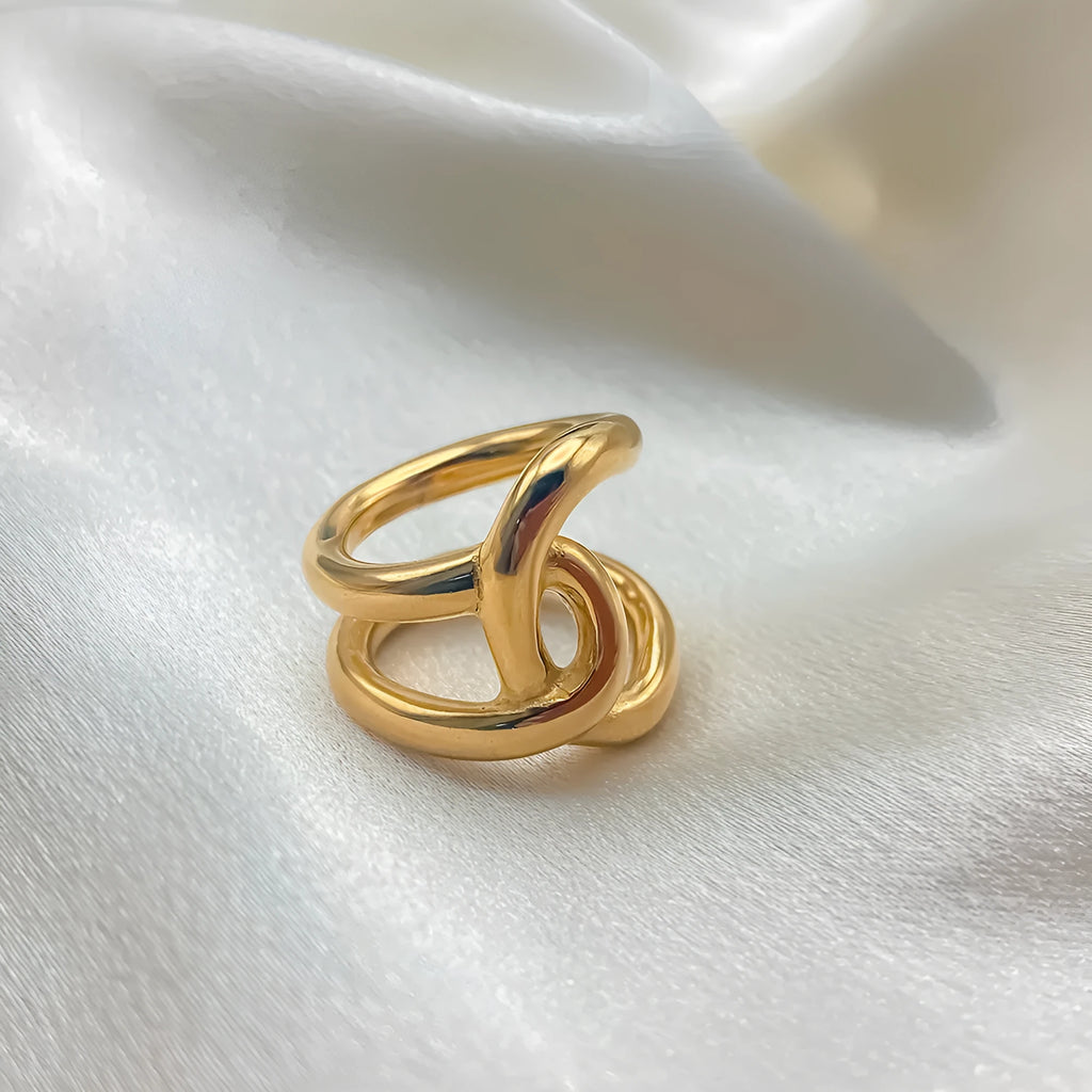 Women's stainless steel knotted geometric adjustable opening ring in gold or silver tone on a hand.