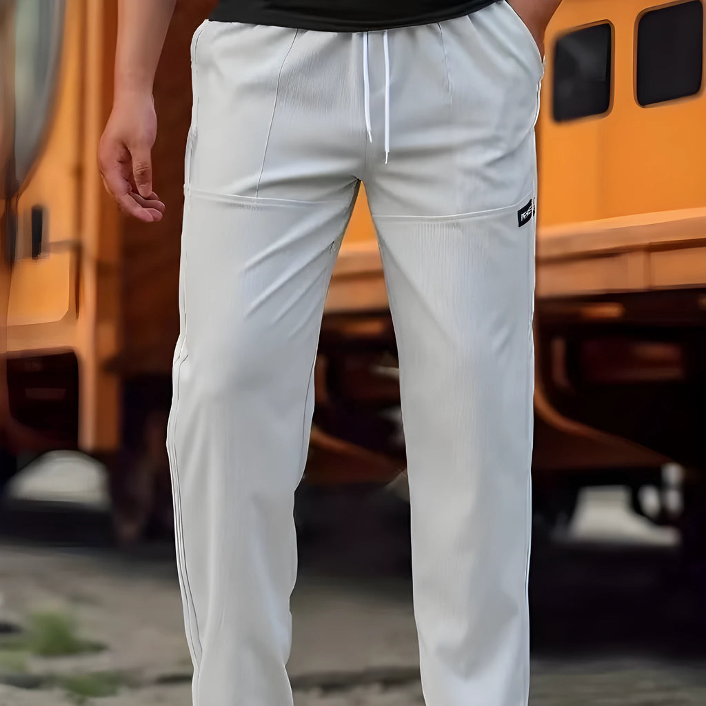 Men's polyester trousers for spring and autumn in light grey, shown in a casual setting.