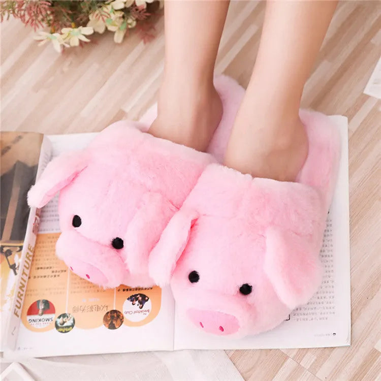 Pink pig-shaped plush floor slippers for adults on a white background.