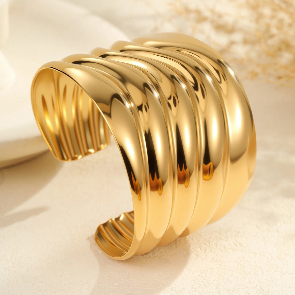 Women's exaggerated wide stainless steel bracelet with 18K gold plating and wave geometric design.
