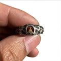 Close-up of a hand-forged copper Grotto Buddha Ring with rock texture, showing the Buddha motif on a size 8 band.